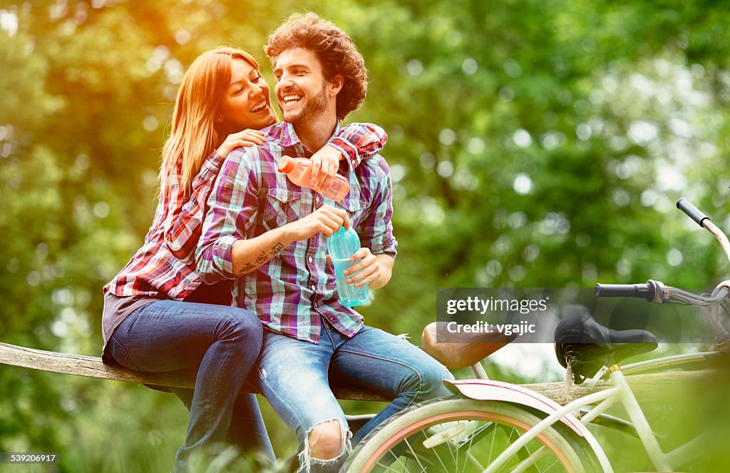 Happy Couple Drinking Water After Riding Bicycles.