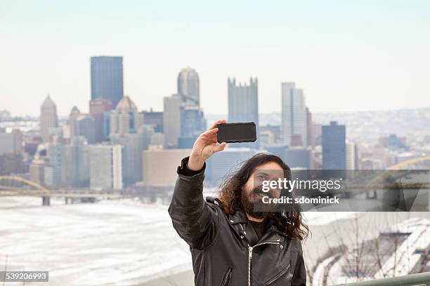 hombre tomando autofoto con sombría invierno horizonte de pittsburgh - ojos marrones fotografías e imágenes de stock