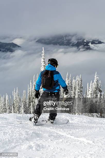 snowboarder above clouds going down the mountain - ski trick stock pictures, royalty-free photos & images