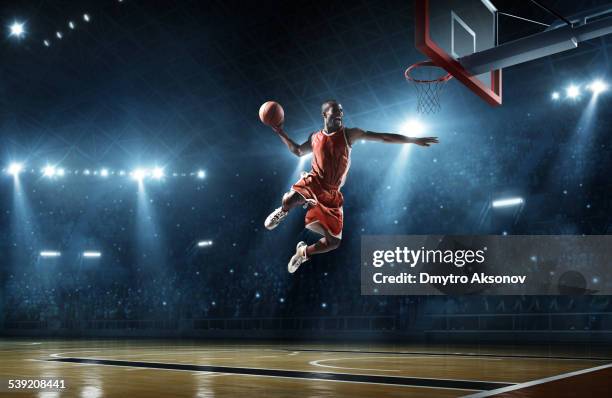 basketball player makes slam dunk - basketball stadium stockfoto's en -beelden