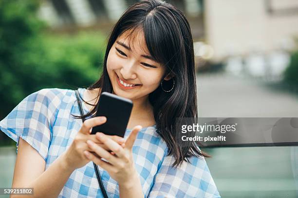 ハッピー十代の女の子メール - 若い カワイイ 女の子 日本人 ストックフォトと画像