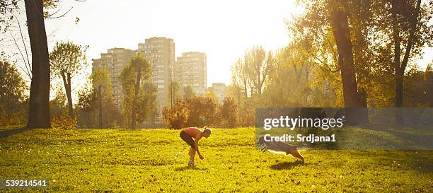 young women playing with her dog - dierentemmer stockfoto's en -beelden