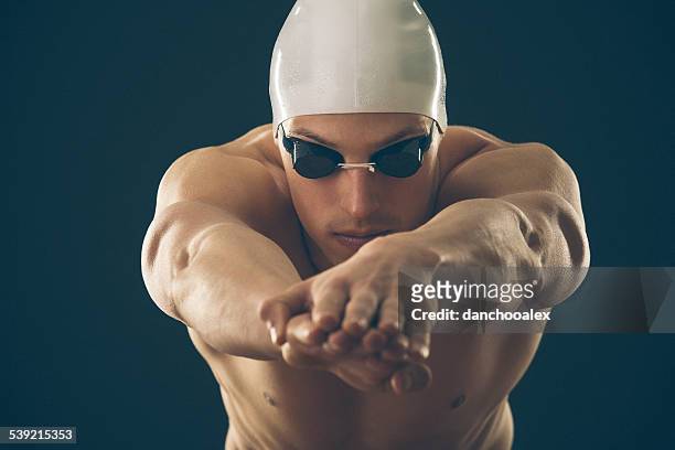 professional male swimmer preparing for jump - butterfly stroke stock pictures, royalty-free photos & images