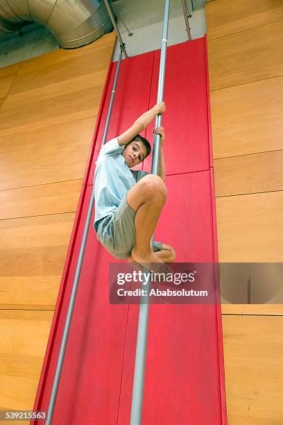 boy climbing, montaje en vertical polos en gimnasio escolar - pole positie fotografías e imágenes de stock