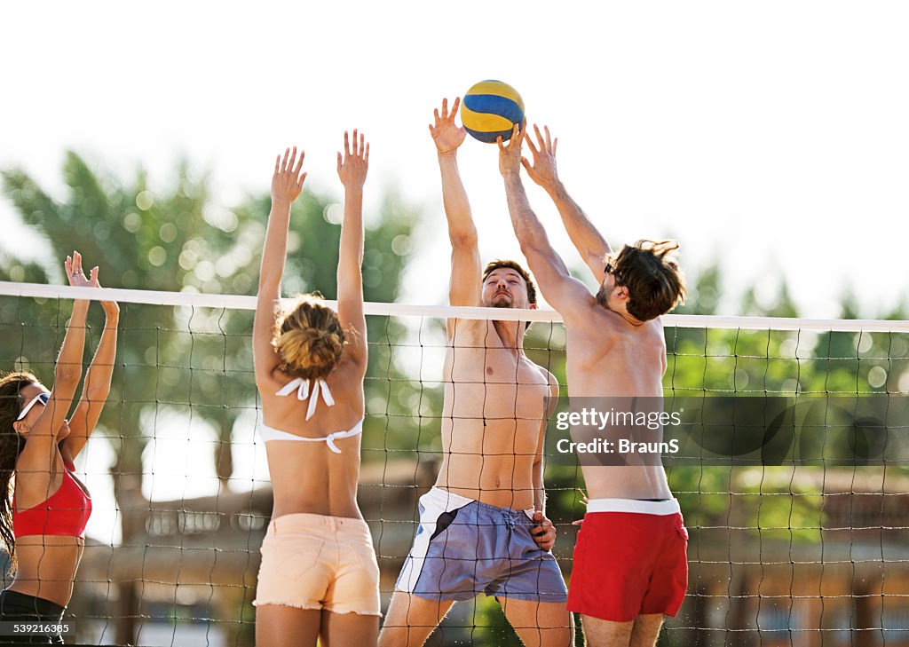 Playing beach volleyball in summer day.