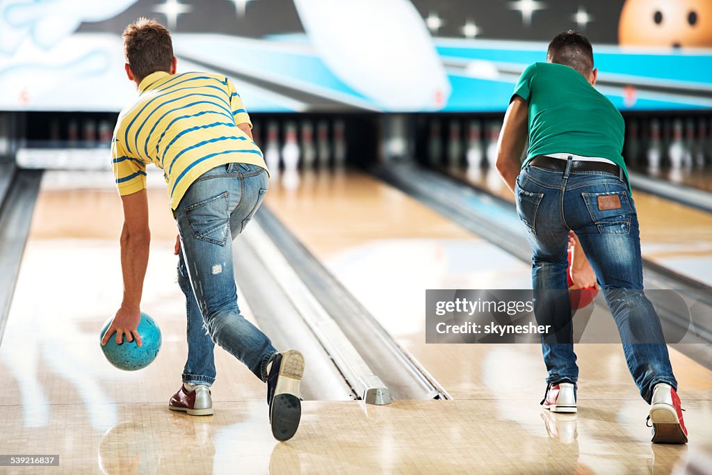 Men throwing a bowling ball.