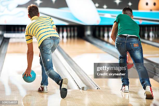 men throwing a bowling ball. - bowling for buddies stock pictures, royalty-free photos & images