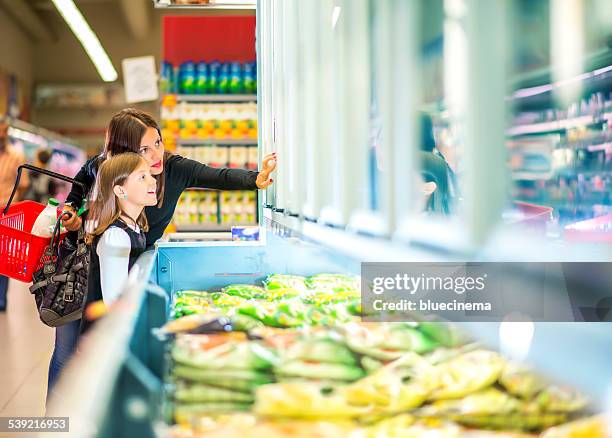 mutter und tochter in der nähe von gefrorene lebensmittel im supermarkt - gefrierkost stock-fotos und bilder