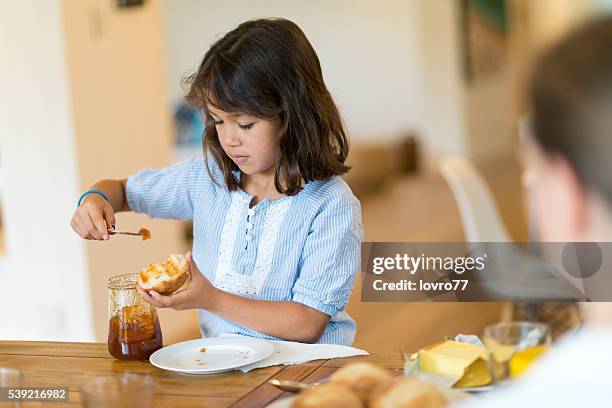 mädchen putting-marmelade auf brot - australian family time stock-fotos und bilder