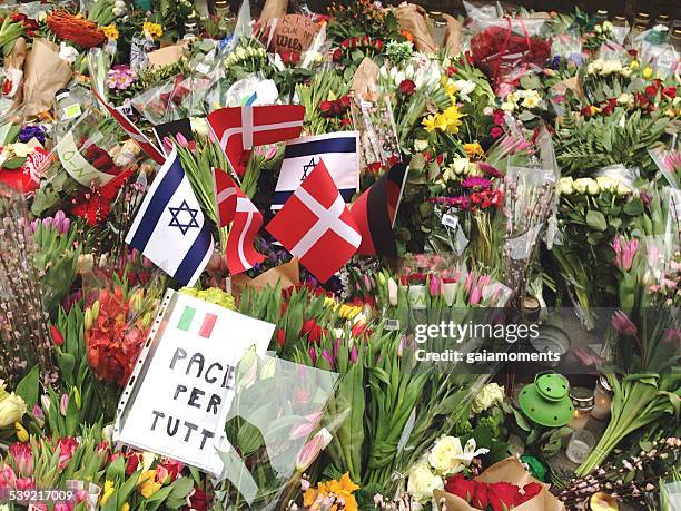 flowers and flags in front of synagogue in copenhagen - terrorisme stockfoto's en -beelden