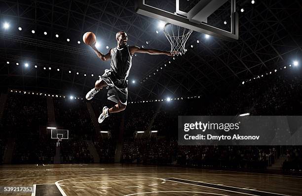 jugador de baloncesto hace slam dunk - salto alto fotografías e imágenes de stock