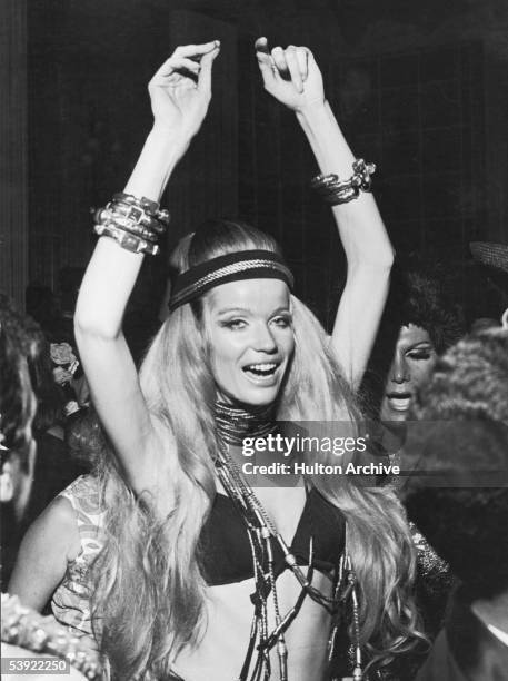 German countess and fashion model Veruschka raises her arms above her head as she dances at a party during Carnaval, Rio de Janeiro, Brazil, February...