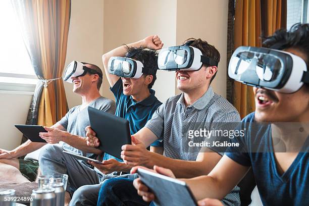 group of friends playing games using virtual reality headsets - game four stockfoto's en -beelden