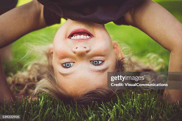 kleines mädchen stehen auf den kopf gestellt. - gymnastics poses stock-fotos und bilder