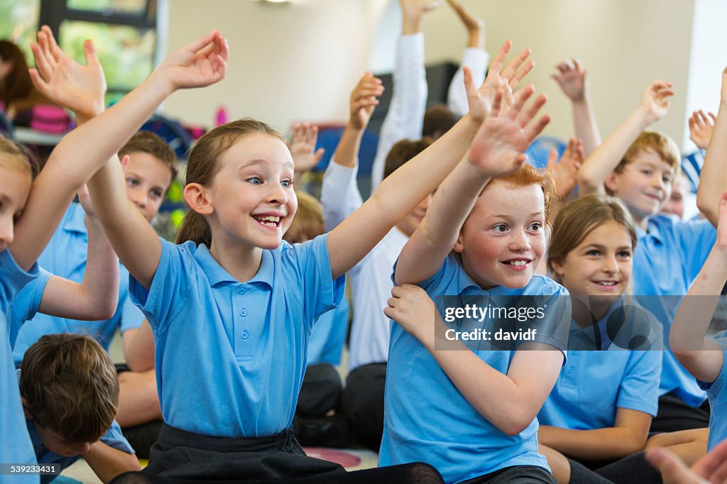 Excited School Children in Uniform with Hands Up