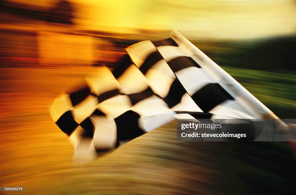 Checkered flag waving at an car race.