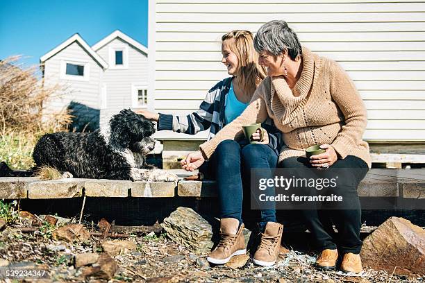 ganmother et petite-fille à nourrir le chien - lunenburg-nova-scotia photos et images de collection