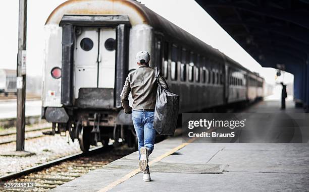 rear view of a man catching the train. - catching train stock pictures, royalty-free photos & images