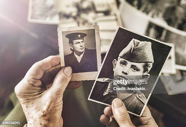 senior frau mit sehr geehrte (r) fotos von ihrem ehemann vor - caucasian ethnicity photos stock-fotos und bilder