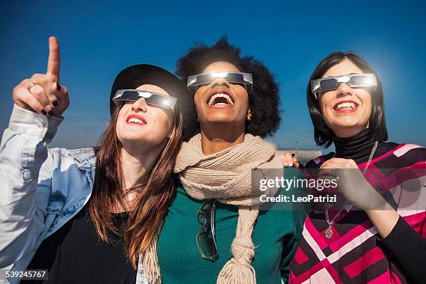 grupo de amigos mirando a un eclipse solar - eclipse fotografías e imágenes de stock