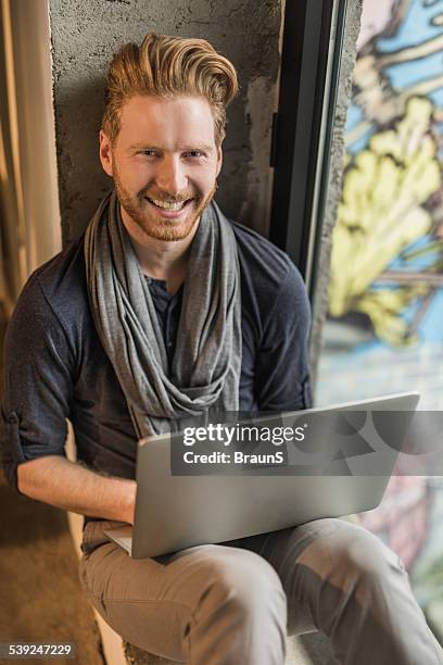 smiling redhead man using laptop. - orange cat computer stock pictures, royalty-free photos & images