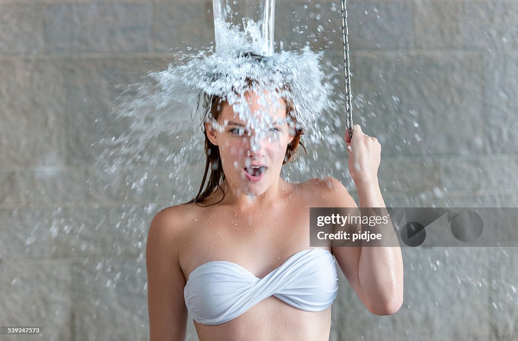Teenage girl taking shower after sauna in health spa