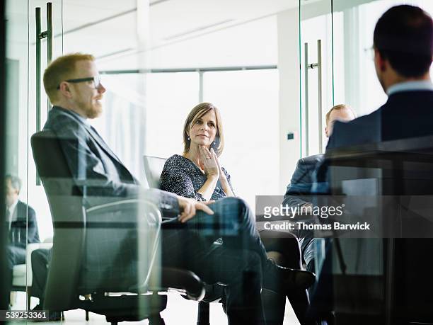 business executive listening to presentation - vestimenta de negocios formal fotografías e imágenes de stock