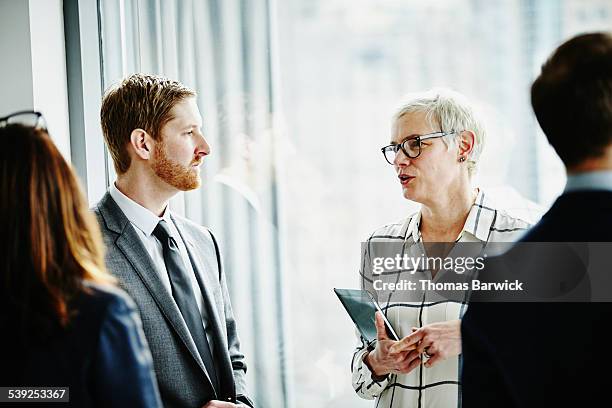 business executives in informal office meeting - costume complet photos et images de collection