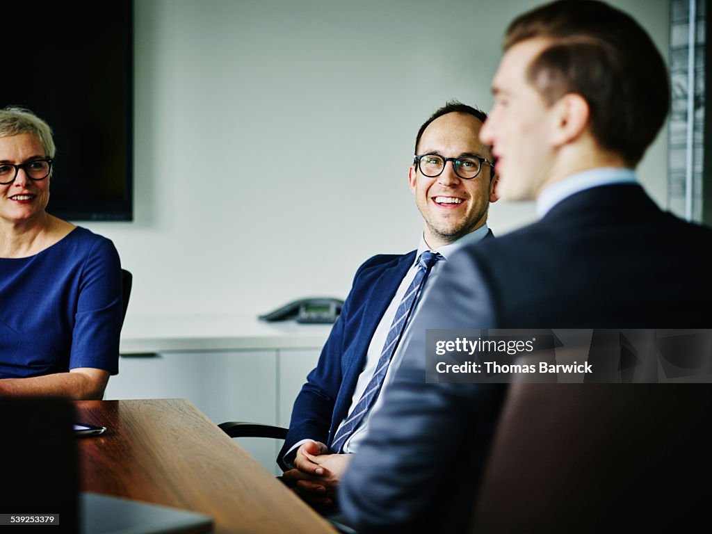 Laughing businesspeople meeting in conference room