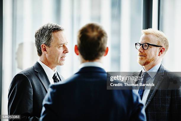 business executives having informal meeting - costume complet photos et images de collection