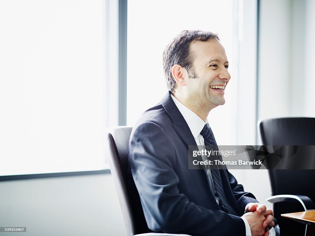 Businessman laughing during meeting in office