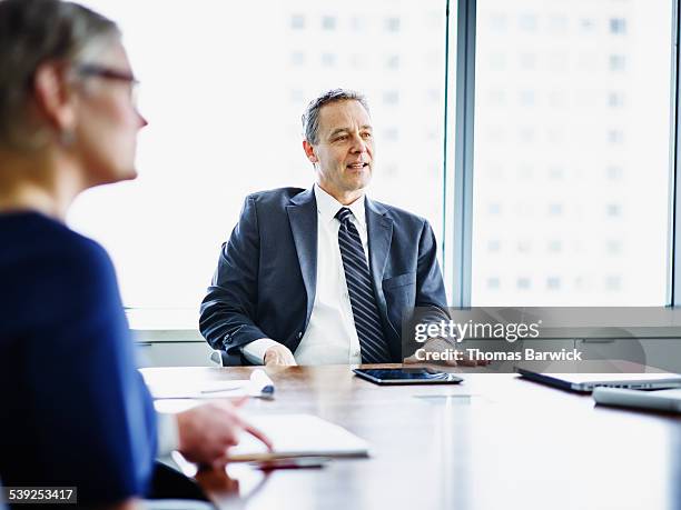 mature business executive leading meeting - meeting candid office suit stock pictures, royalty-free photos & images