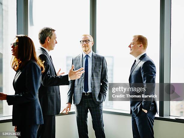 business executives having informal office meeting - meeting candid office suit stock pictures, royalty-free photos & images