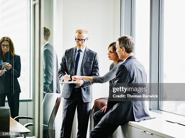 business executives collaborating on project - businesswear stock pictures, royalty-free photos & images
