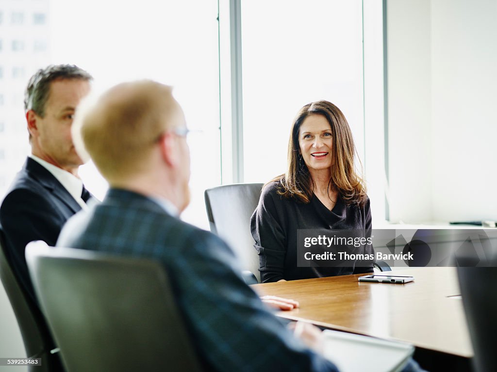 Business executive leading meeting with colleagues