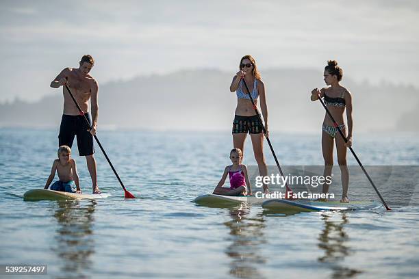 family paddleboarding in hawaii - hawaii vacation and parent and teenager stock pictures, royalty-free photos & images