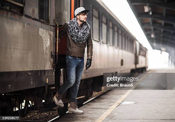 young man getting off the train. - disembarking train stock pictures, royalty-free photos & images