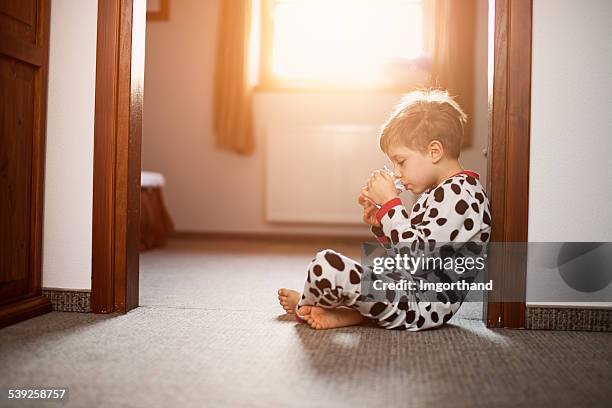 little boy wearing pijama beber mañana vaso de agua. - niño-tomando-agua fotografías e imágenes de stock