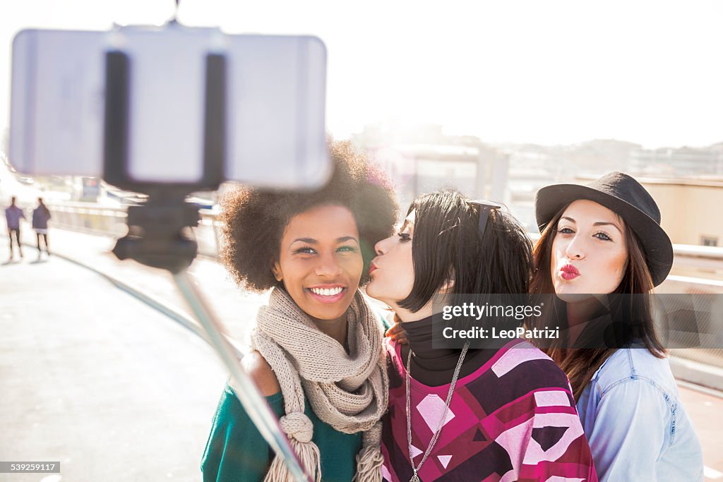 Women friend outdoor taking selfies with selfie stick