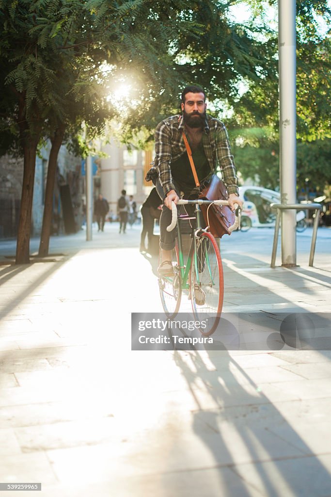 Young hipster hombre velocidad con su bicicleta.