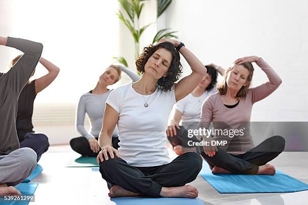 gruppe von menschen, die ausübung in yoga-klasse - hals stock-fotos und bilder