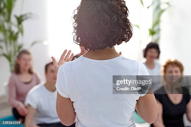 femme professeur aider les étudiants pendant les cours de yoga - coacha photos et images de collection