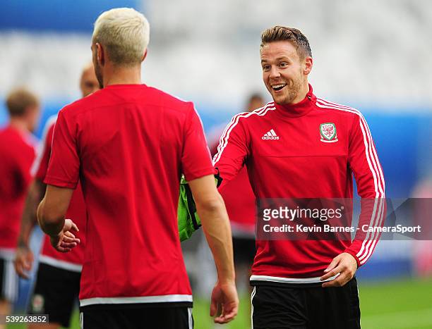 Wales's Chris Gunter hands a bib to Wales's Aaron Ramsey during the training session at the Stade de Bordeaux on June 10, 2016 in Bordeaux, France...