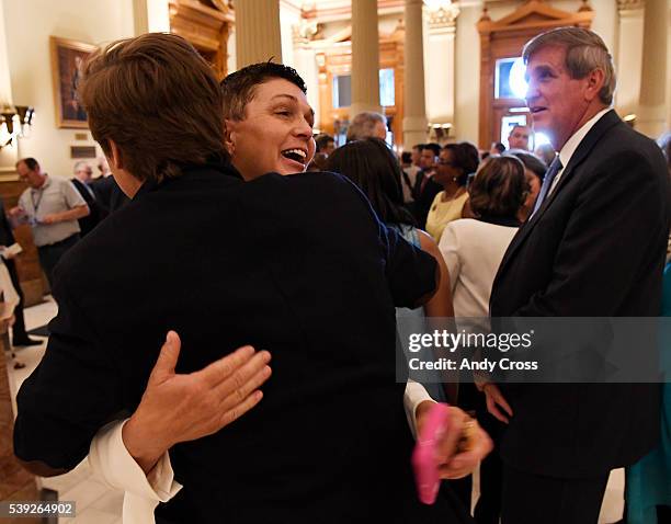 Alleged rape victim Beth Ferrier, center, hugs Colorado Senator Mike Johnston, , left, co-sponsor of HB-1260, in the foyer of the Colorado State...