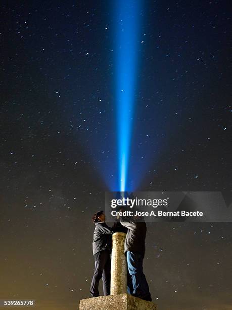 men with his close hands illuminating the night sky with a bundle of light. - flashlight dark stock pictures, royalty-free photos & images