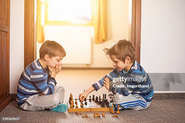 little boys playing chess together - kids playing chess stock pictures, royalty-free photos & images