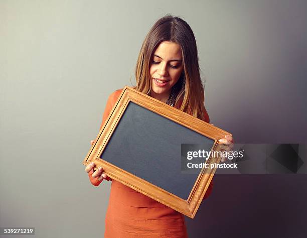 woman showing board in front of the wall. - happy people holding a white board stock pictures, royalty-free photos & images