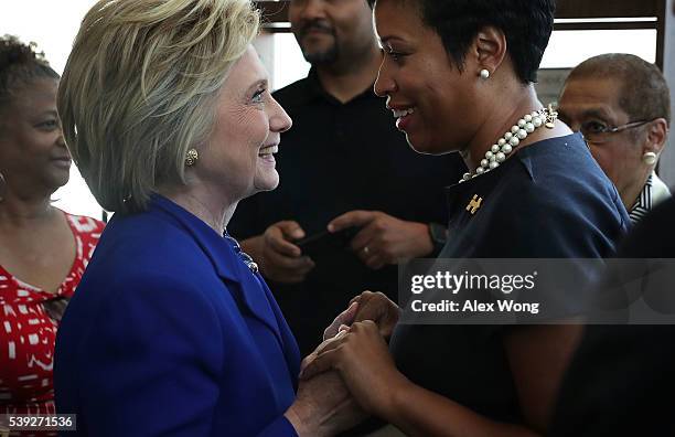 Democratic presidential candidate Hillary Clinton greets DC Mayor Muriel Bowser during a visit to Uprising Muffin Company June 10, 2016 in...