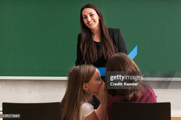 attractive teacher with long hair standing at blackboard - green blazer stock pictures, royalty-free photos & images