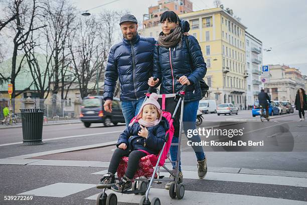 famille heureuse en traversant la rue - femme poussette rue photos et images de collection